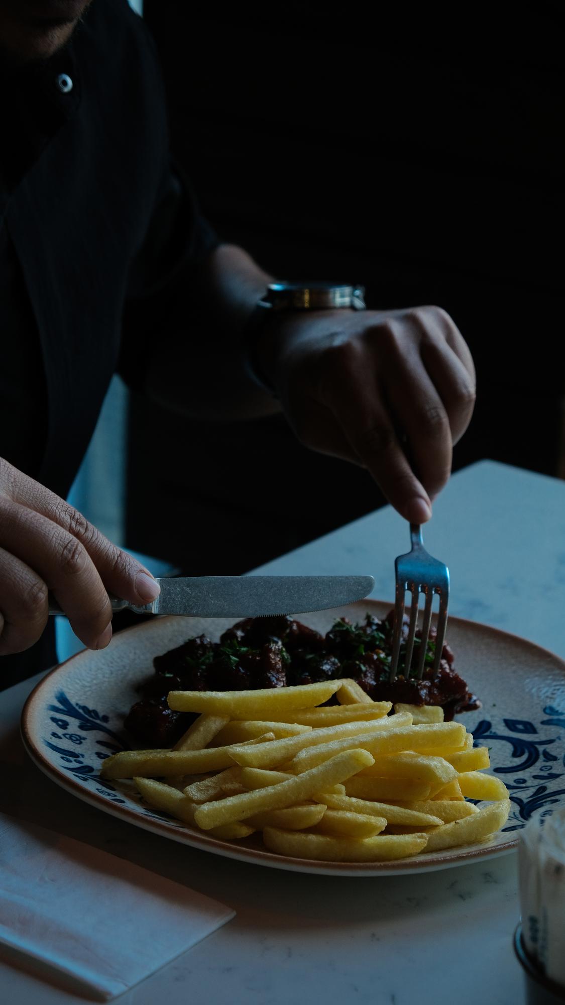 Chef adjusting a plated course under lamp